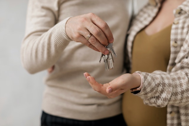 two people standing close together holding house keys